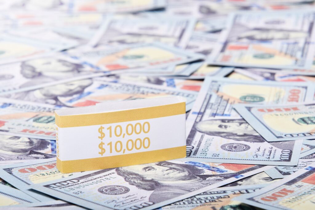 Close-up of a $10,000 stack of US dollars with a currency band, highlighting wealth and finance.
